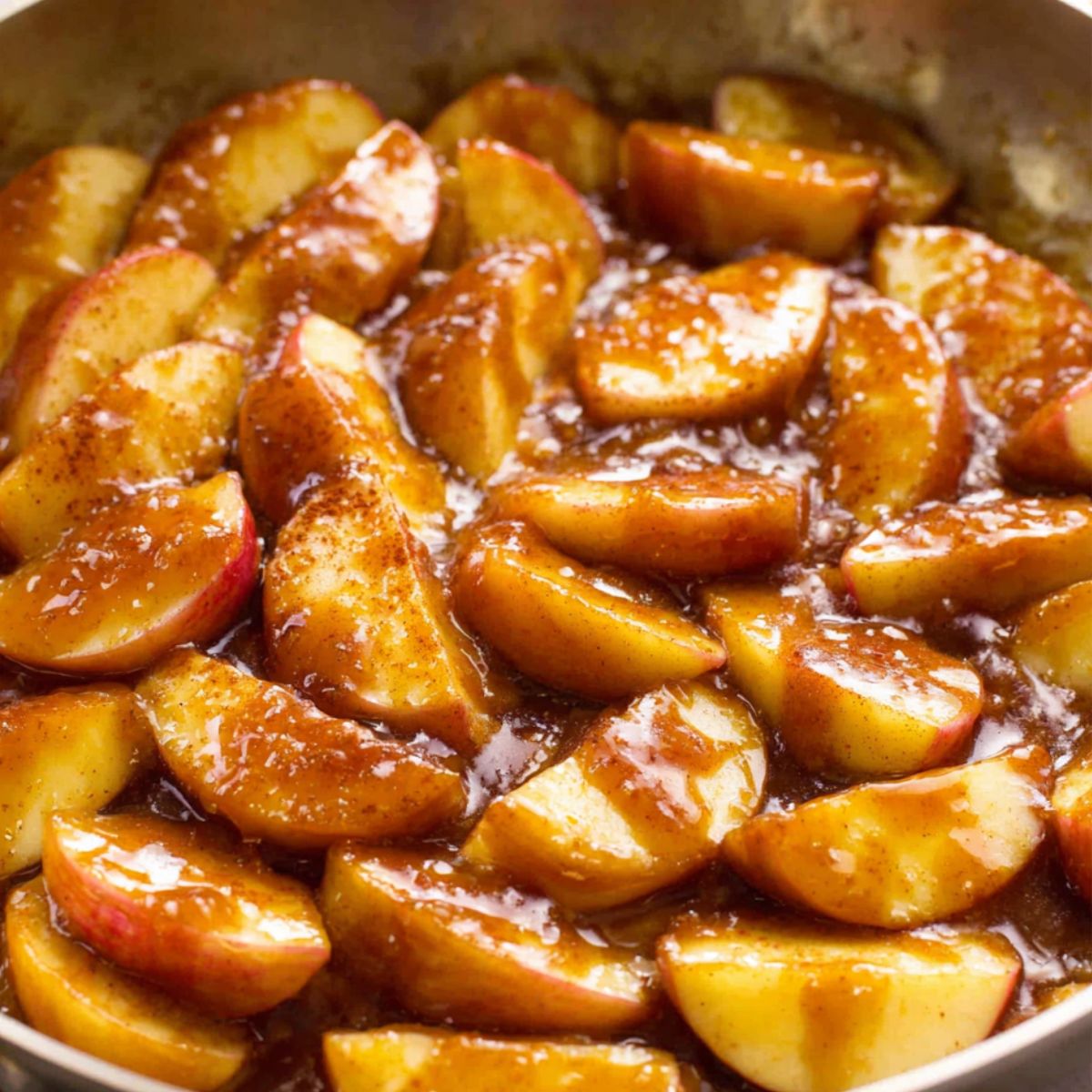 Apple slices caramelizing in a skillet with butter and brown sugar
