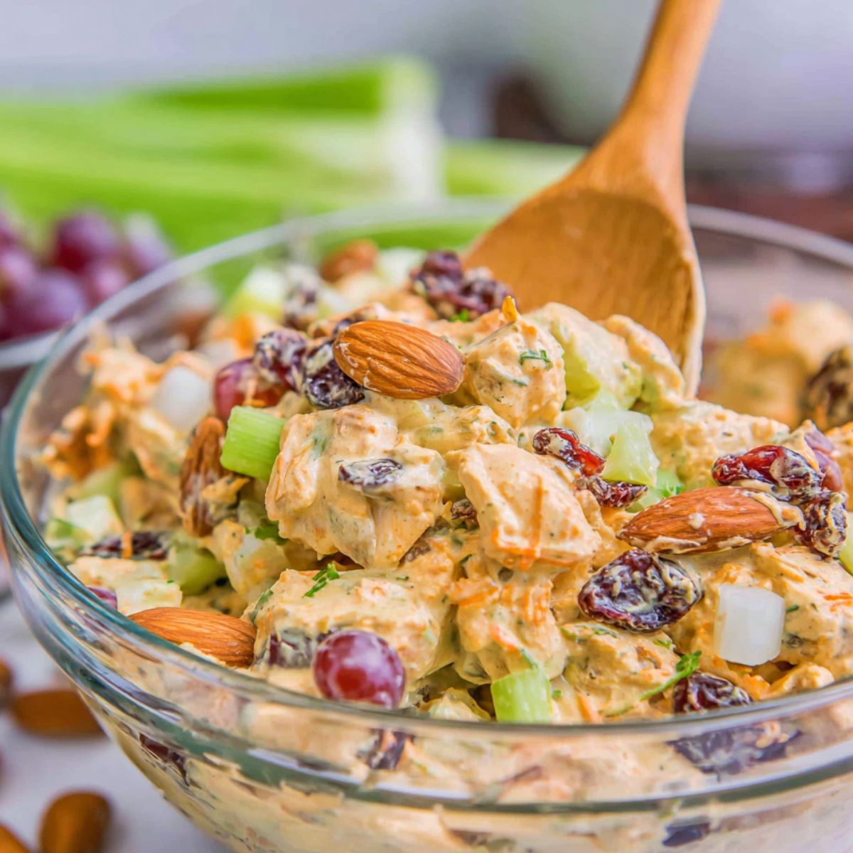 Mixing chicken, vegetables, and curry dressing in a large bowl