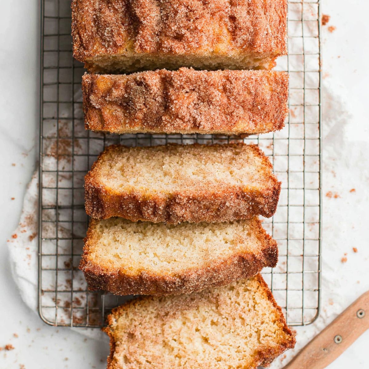 Sliced cinnamon donut bread cooling on a wire rack, ready to serve.