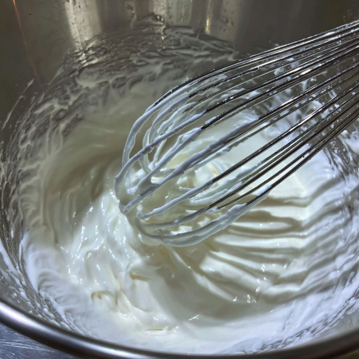Eggs and sugar being whisked into a pale fluffy mixture