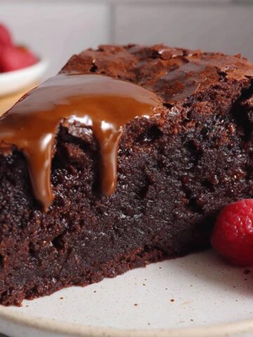 Rich and gooey homemade slice of brownie cake on a white counter