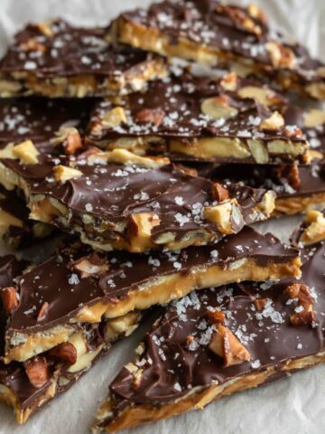 Homemade date snickers bark cut into rustic squares on parchment paper
