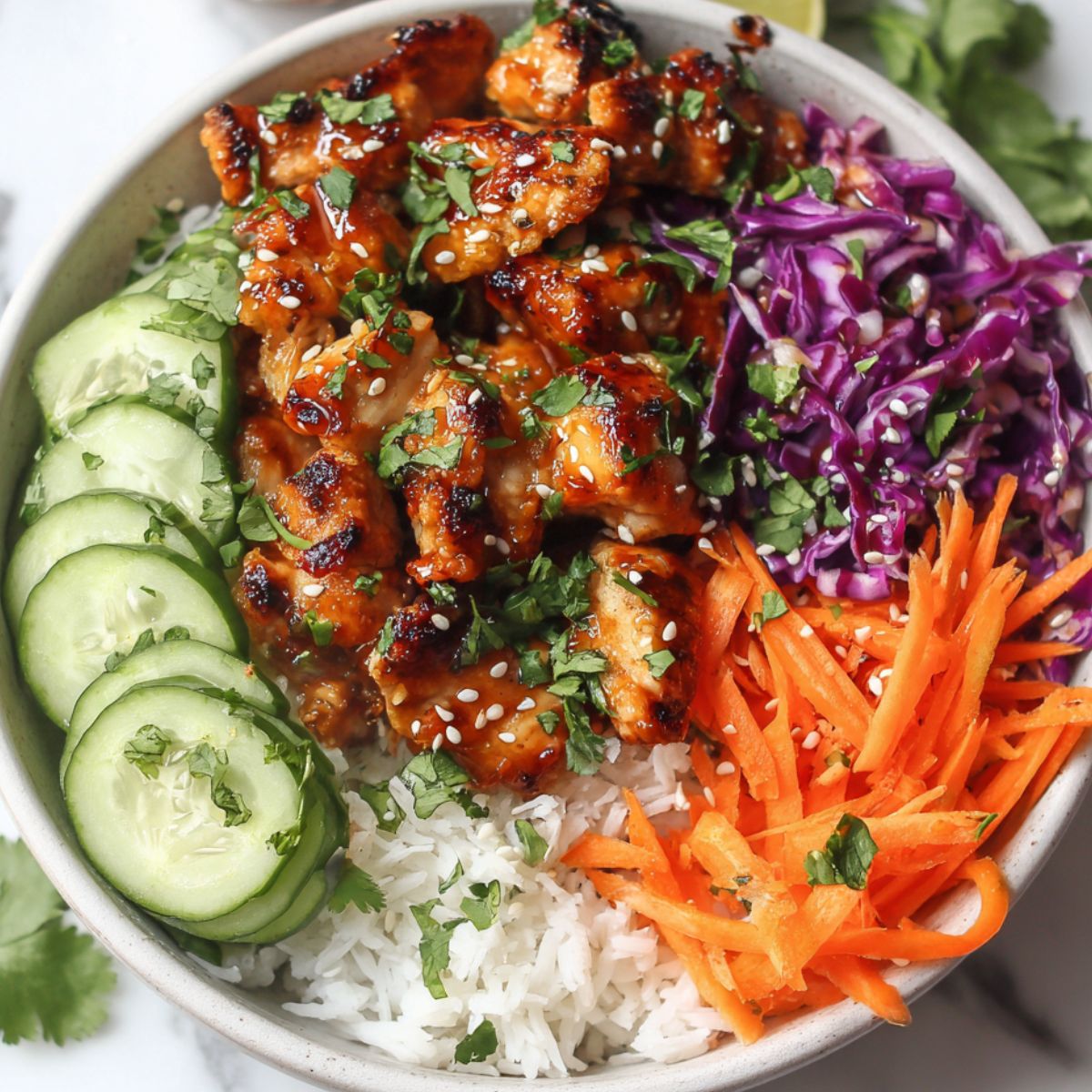 Homemade Bang Bang Chicken Bowl with crispy chicken, rice, and fresh vegetables on a white kitchen counter.