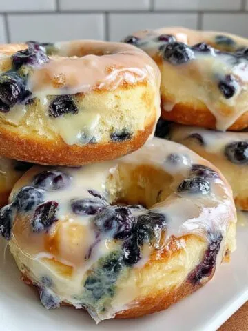 Homemade blueberry donuts on a white kitchen counter with glaze