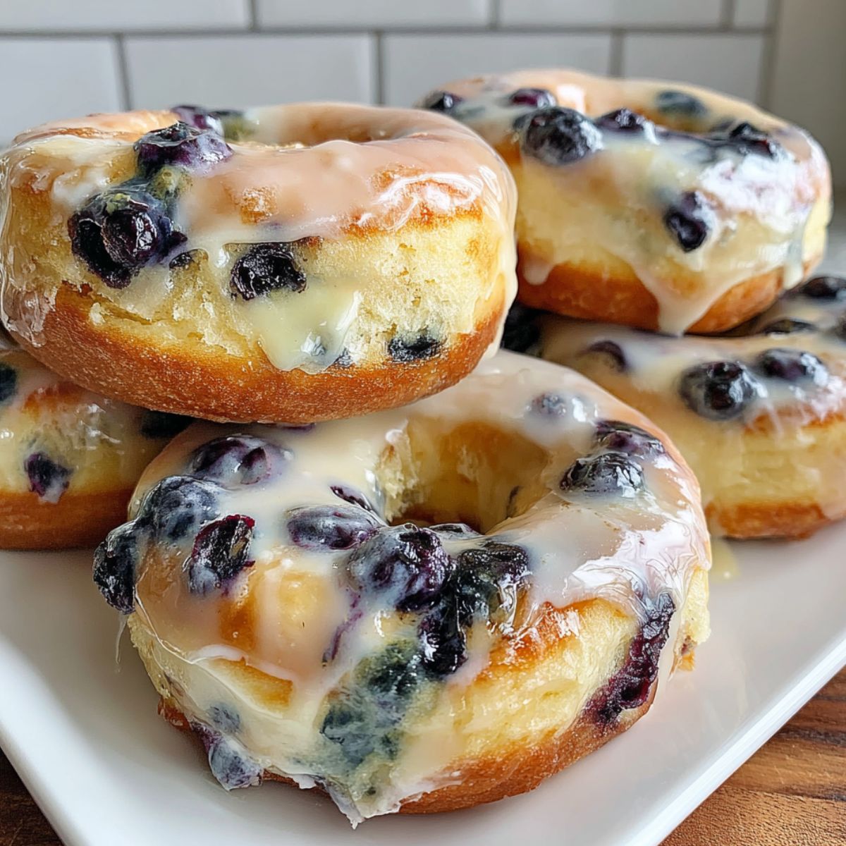 Homemade blueberry donuts on a white kitchen counter with glaze