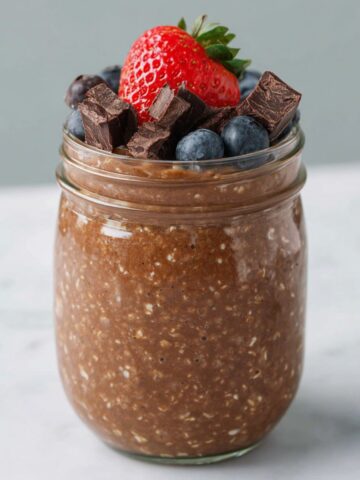 Overhead shot of homemade brownie batter overnight oats in a jar on a kitchen counter