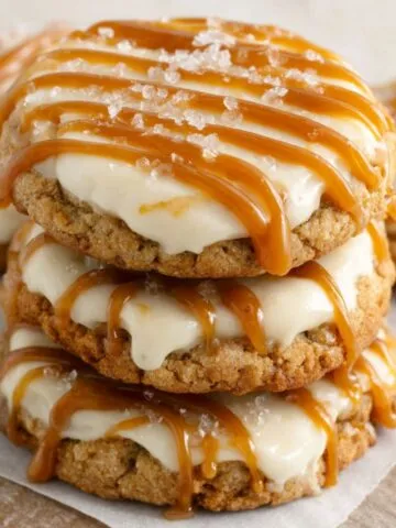 Homemade Salted Caramel Cheesecake Cookies drizzled with caramel on a kitchen counter