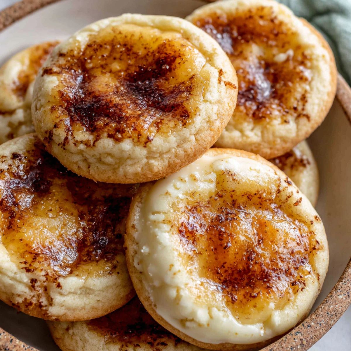 Homemade crème brûlée cookies with caramelized sugar topping on a white kitchen counter, 
