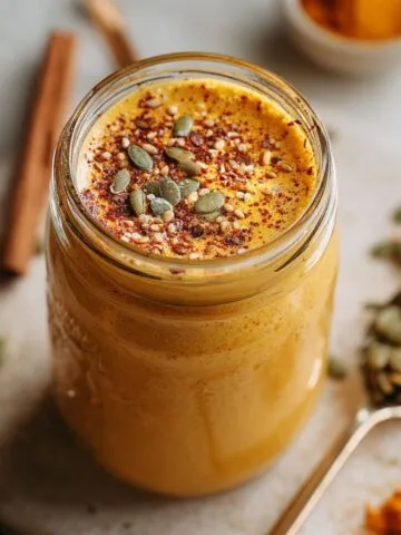 Homemade healthy pumpkin smoothie in a mason jar on white kitchen counter