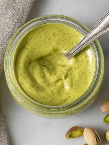 Homemade pistachio cream in a jar on white kitchen counter