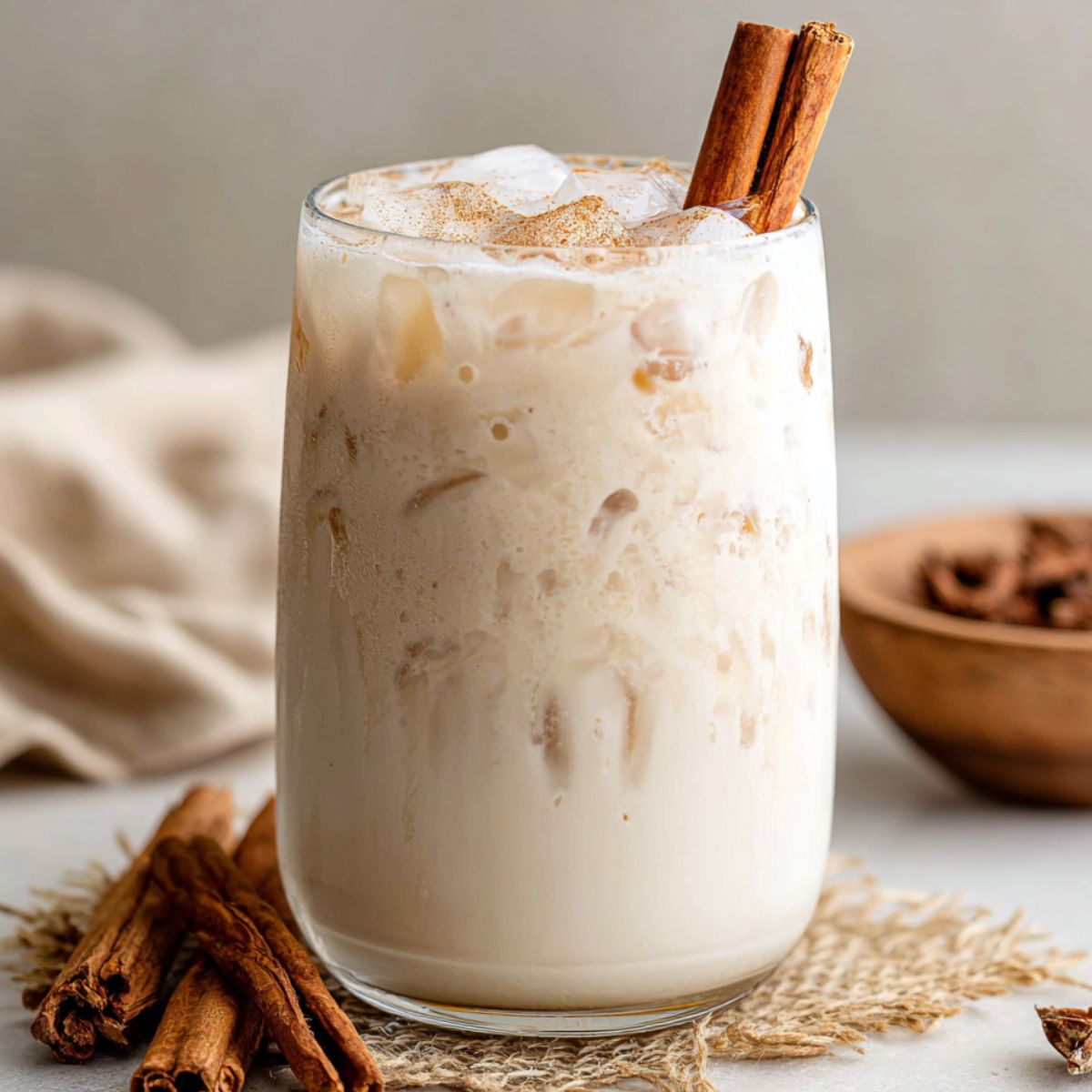 Homemade healthy horchata served with ice and cinnamon on a white kitchen counter, top-down view.