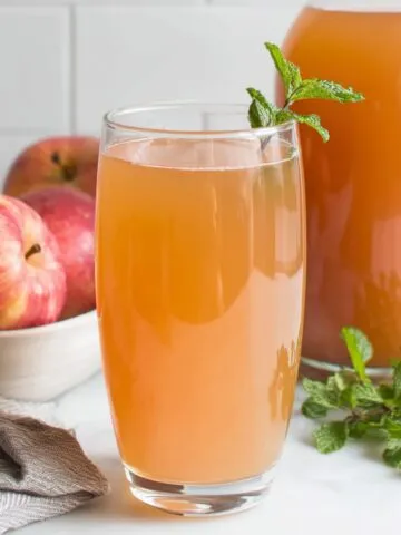 Homemade Sugar Free Apple Juice in a glass on white counter