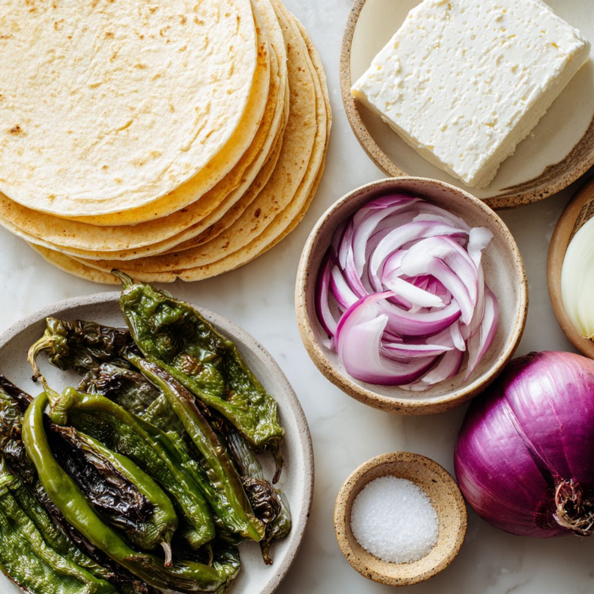 Flat lay of ingredients for quesadillas fritas mexicanas on a white countertop with a casual homemade setup