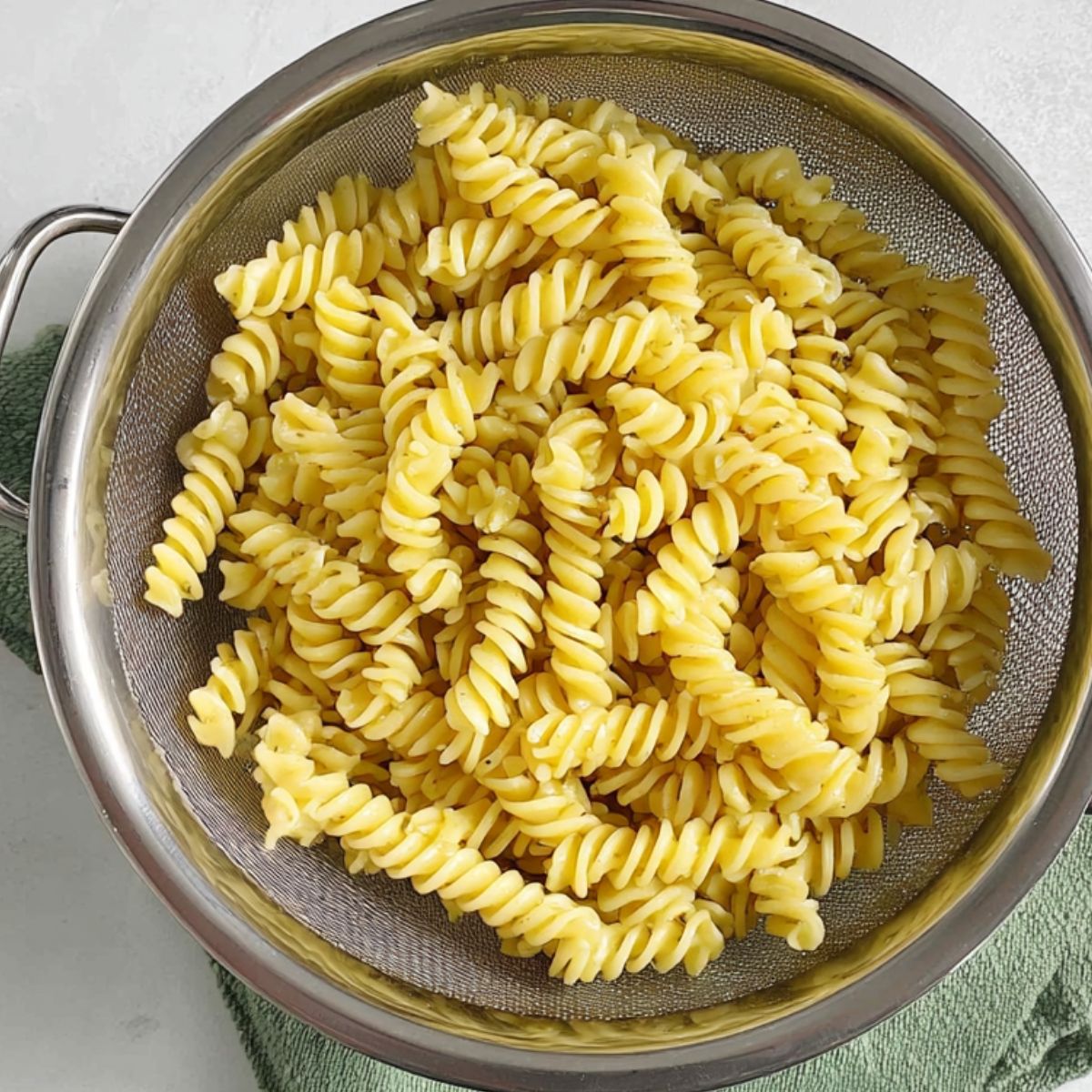 Drained cooked pasta in a colander over the sink