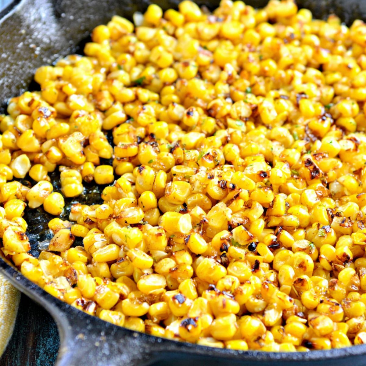Corn kernels charring in a skillet for Mexican street corn dip.
