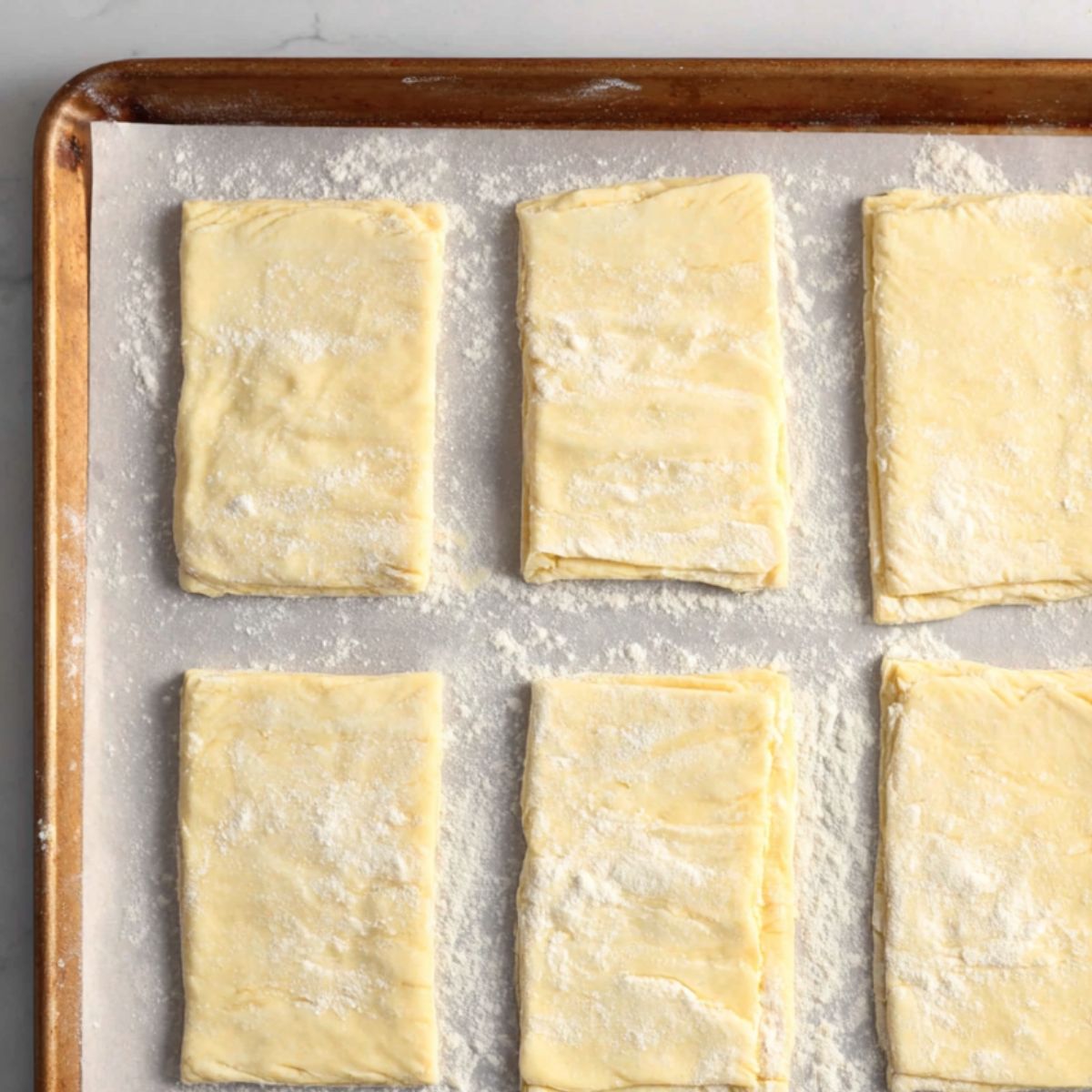 Cut and score puff pastry rectangles on parchment paper