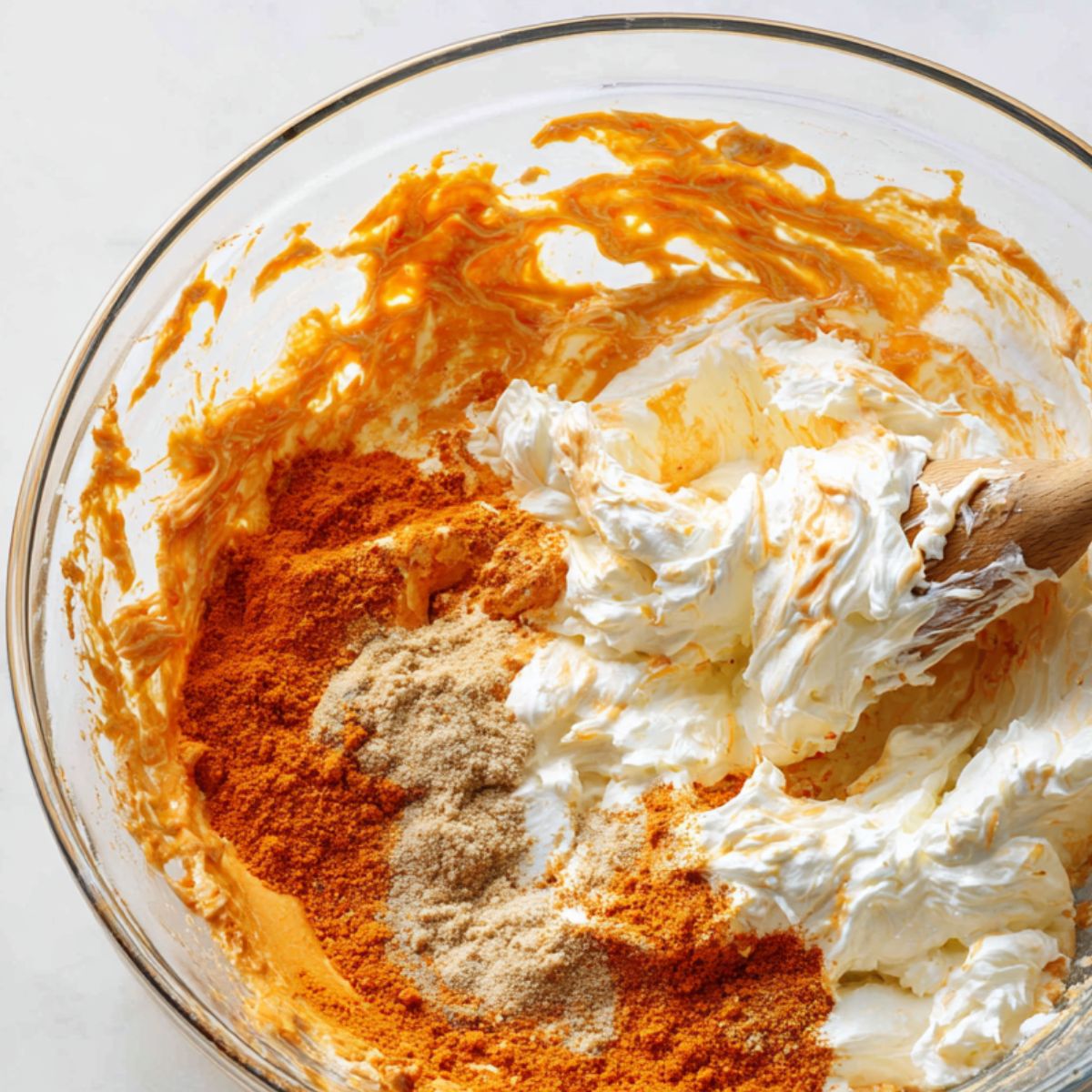 Creamy buffalo dip base being mixed in a large bowl from top view