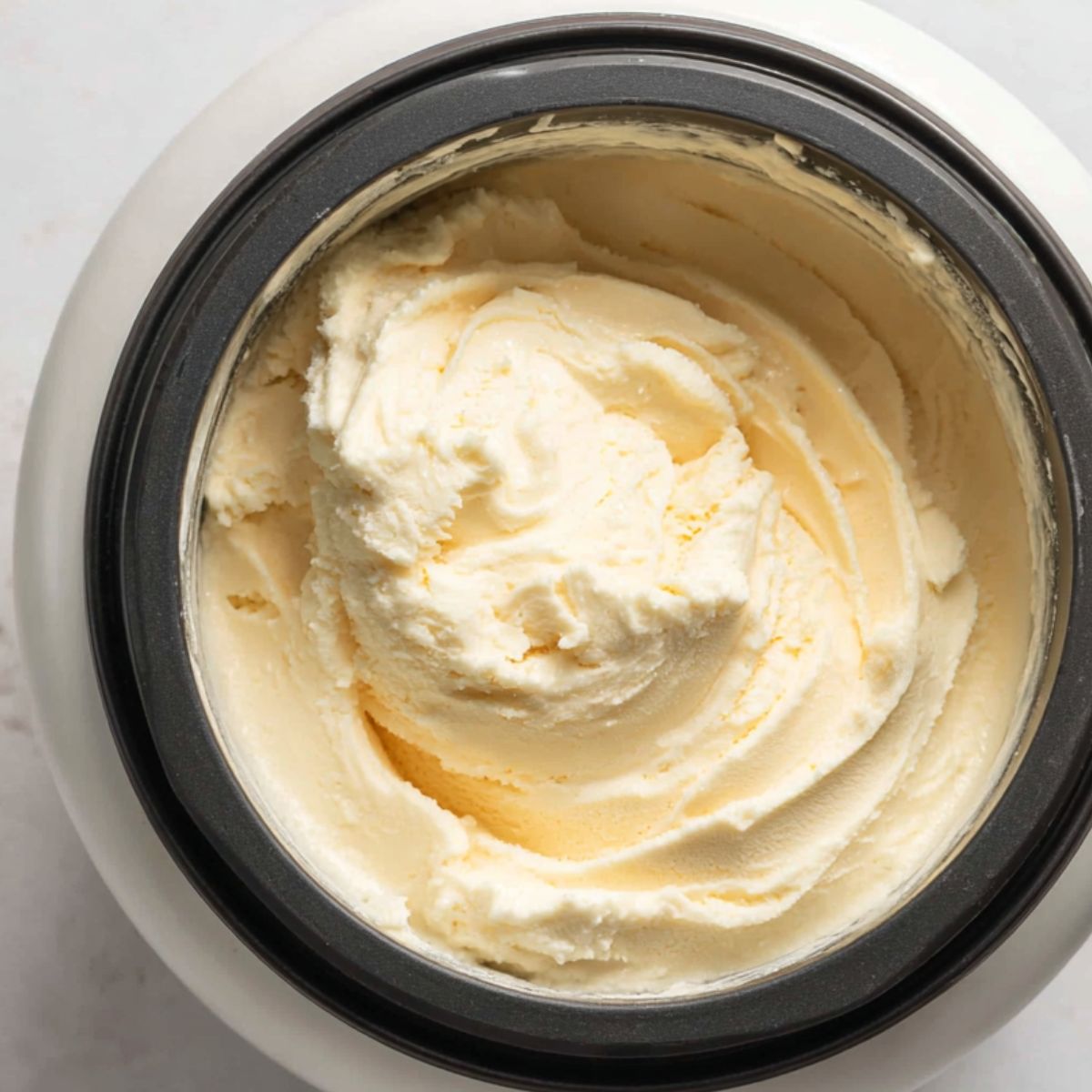 Custard mixture churning inside a home ice cream maker.