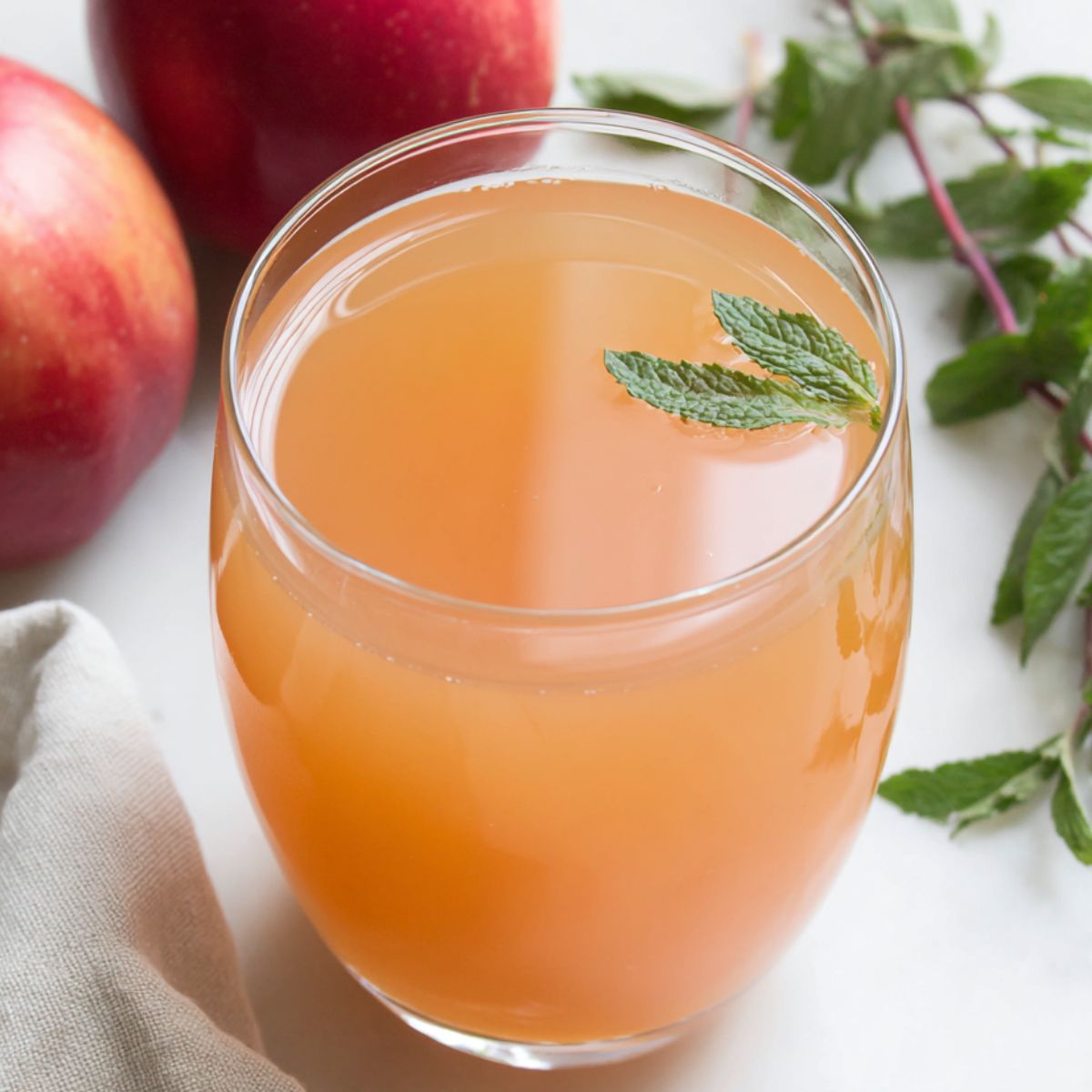 Fresh apple juice served in a glass with mint