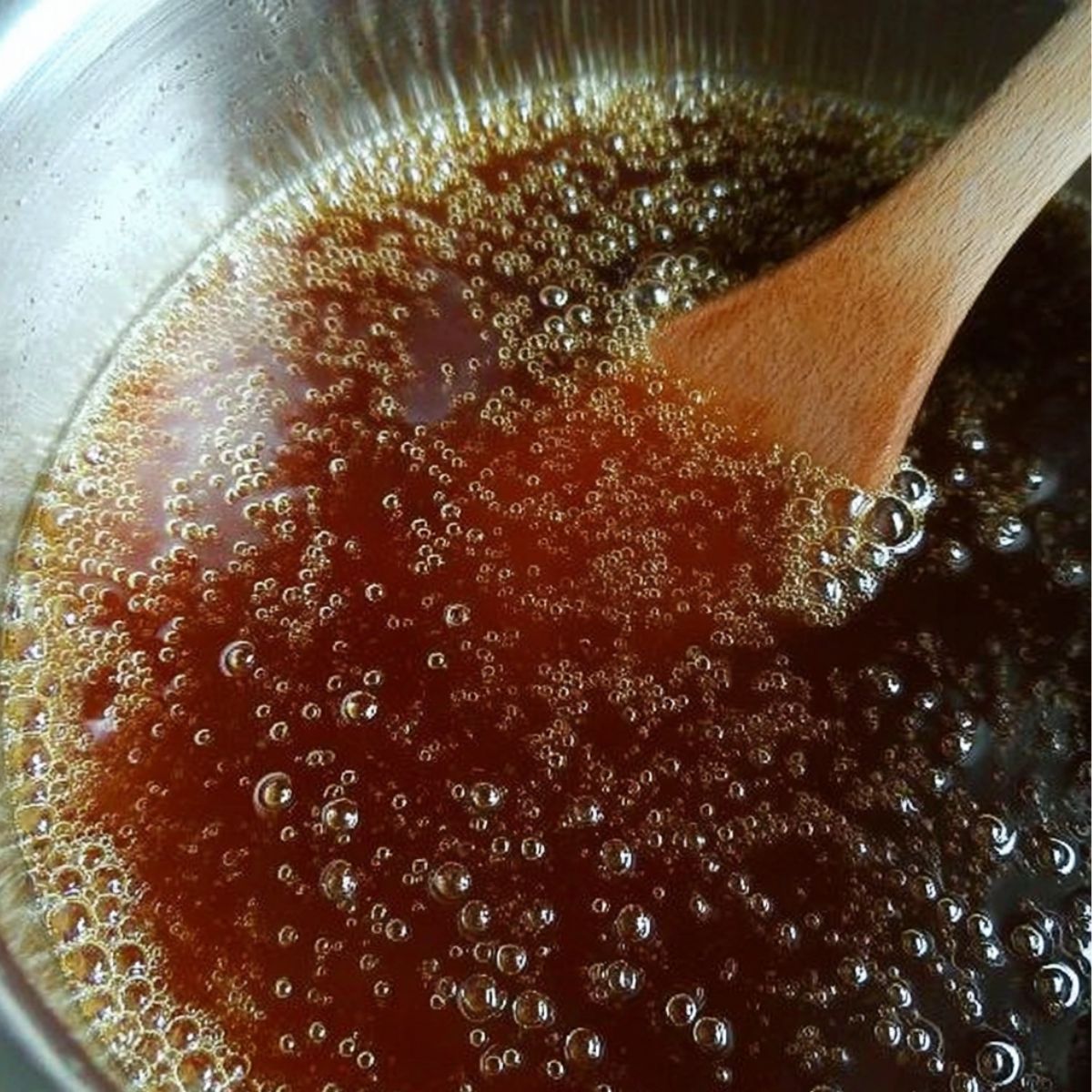 Simple syrup simmering in a saucepan for vanilla coffee syrup.