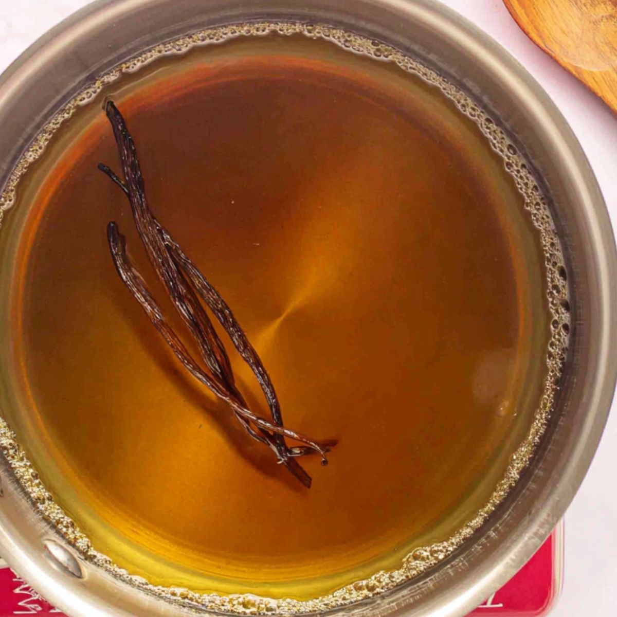 Adding vanilla extract to warm syrup for homemade coffee syrup.