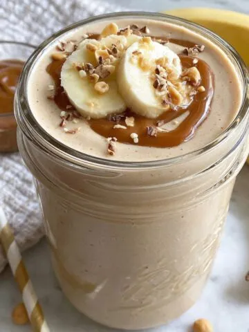 Homemade weight gain smoothie in a mason jar on a white kitchen counter, photographed from above.