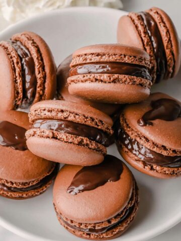 Homemade chocolate macarons recipe , arranged on a white kitchen counter