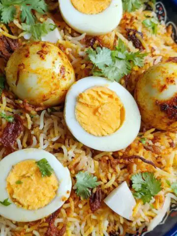 Homemade egg dum biryani in a rustic pot on a kitchen counter