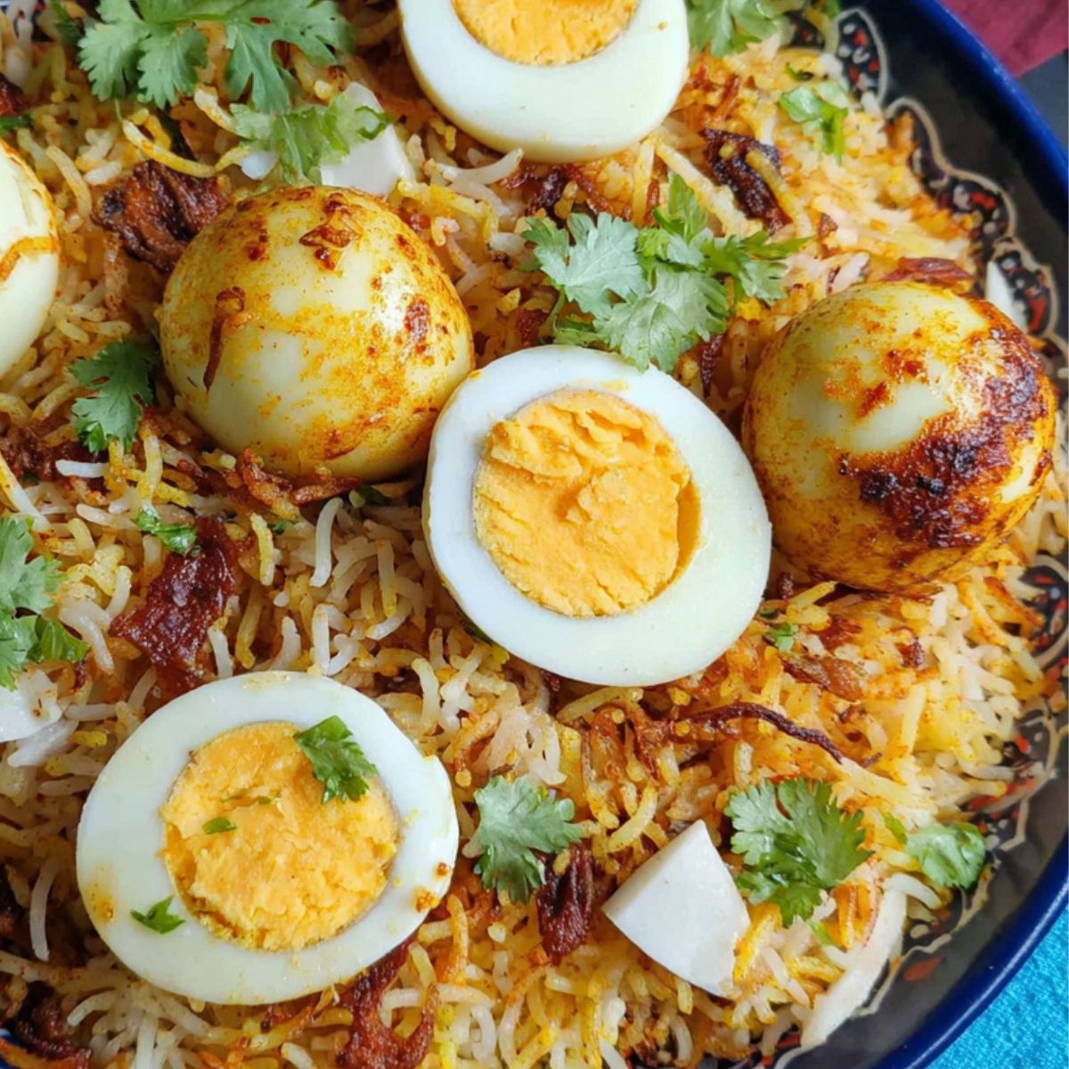 Homemade egg dum biryani in a rustic pot on a kitchen counter