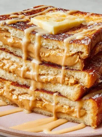homemade Hong Kong French Toast with butter and condensed milk drizzle on a white kitchen counter.