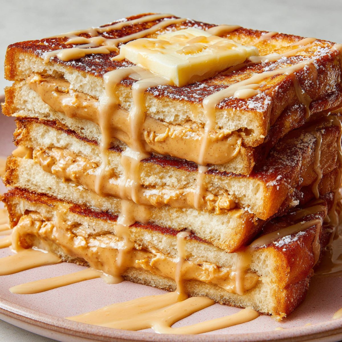 homemade Hong Kong French Toast with butter and condensed milk drizzle on a white kitchen counter.