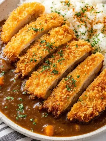 Homemade Japanese Curry Recipe Chicken Katsu with rice and curry sauce on a white plate