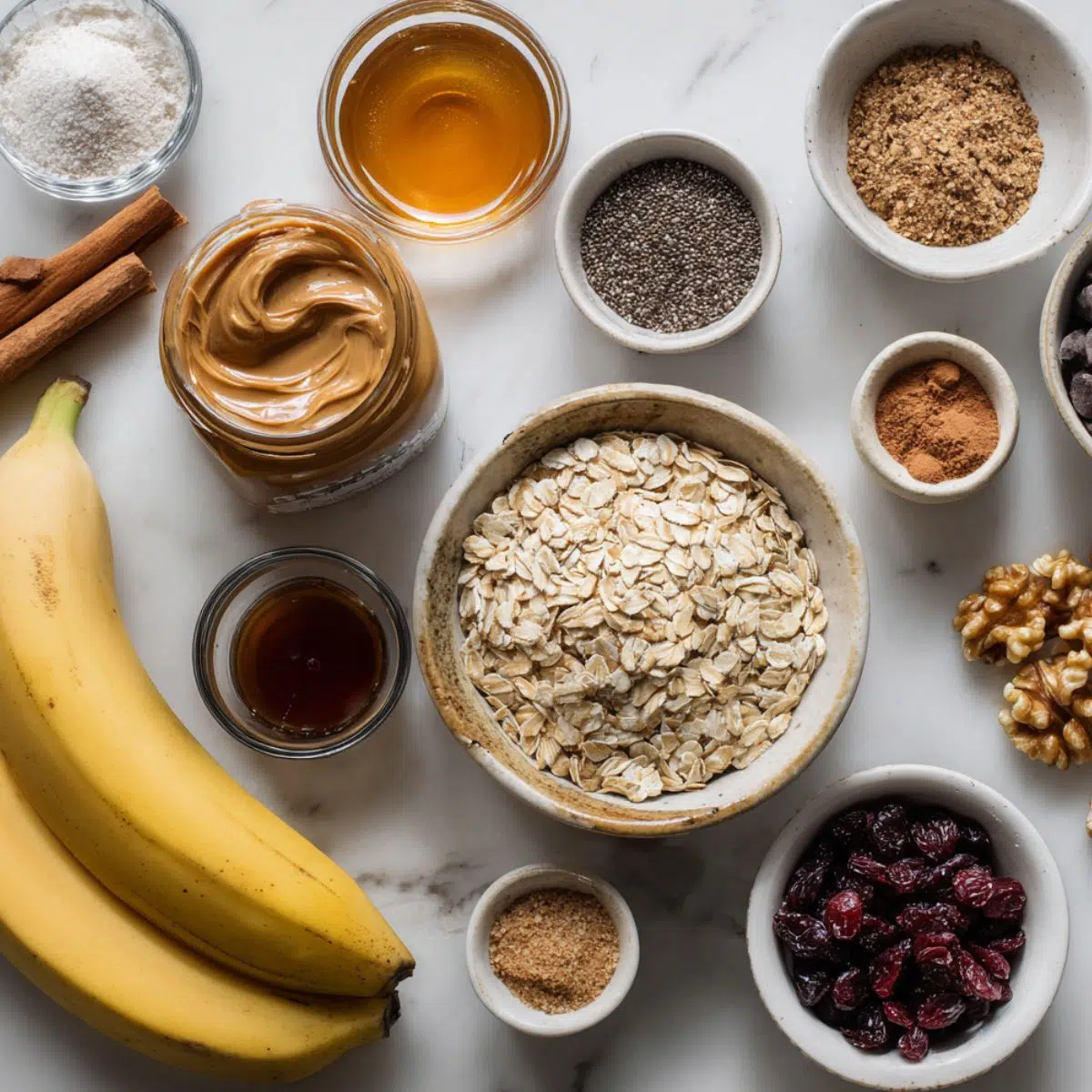 Flat lay of ingredients to make oatmeal banana bars on a white kitchen counter with natural light.