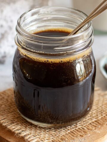 Homemade Mocha Syrup for Coffee in a glass bottle on a white kitchen counter