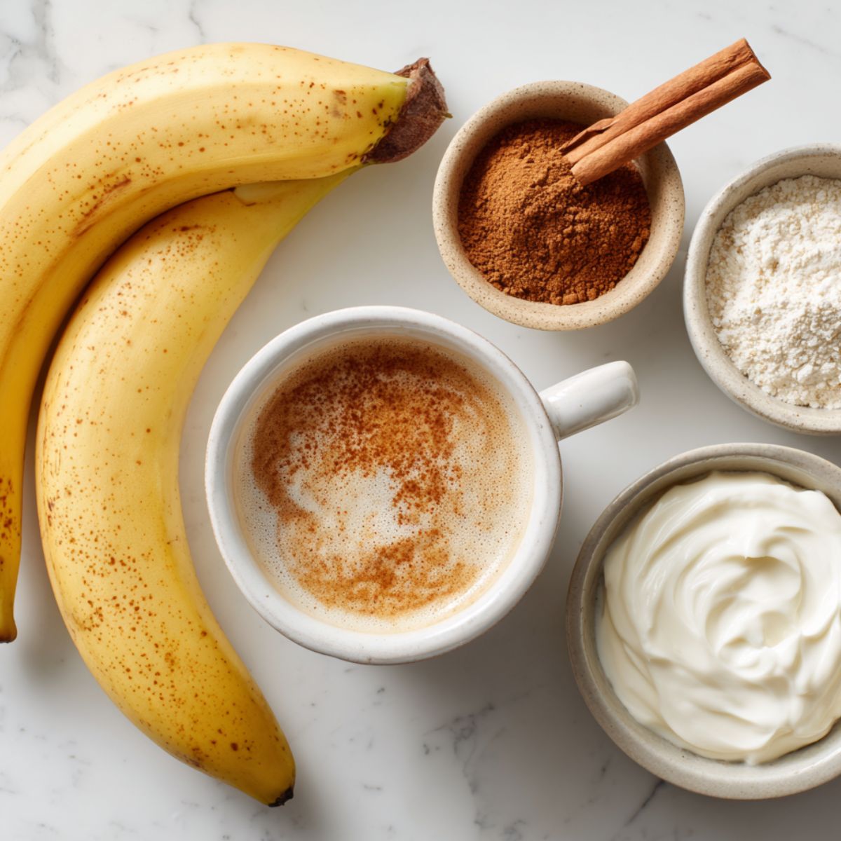 Coffee banana smoothie ingredients casually arranged on a white kitchen counter, top-down photo with natural lighting.