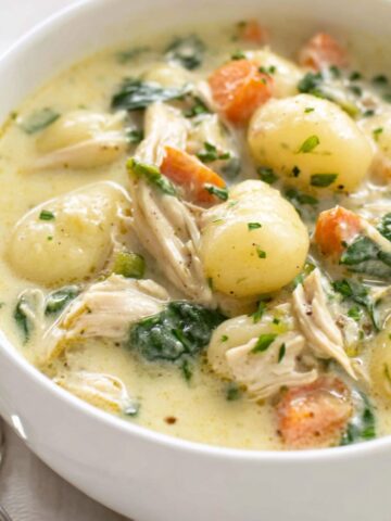 A homemade bowl of creamy gnocchi soup on a white kitchen counter