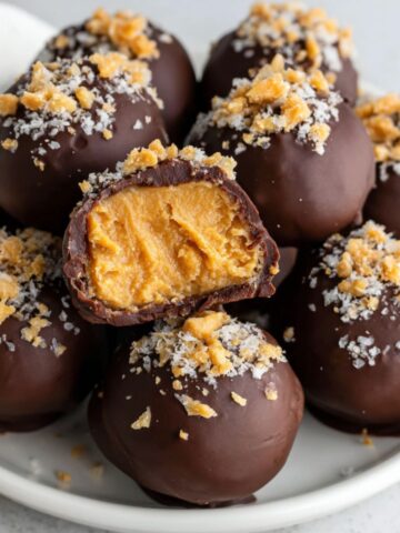 Homemade peanut butter chocolate balls on a white kitchen counter with natural light.