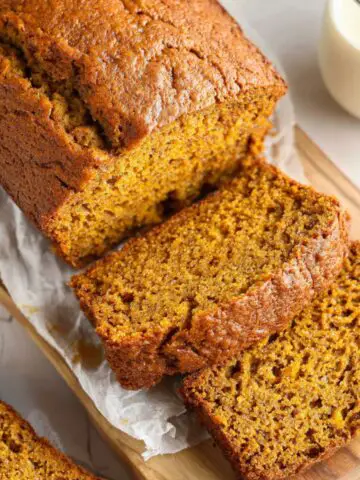 Overhead view of a homemade banana pumpkin bread loaf on a white kitchen counter, showing its golden crust and cozy fall texture.