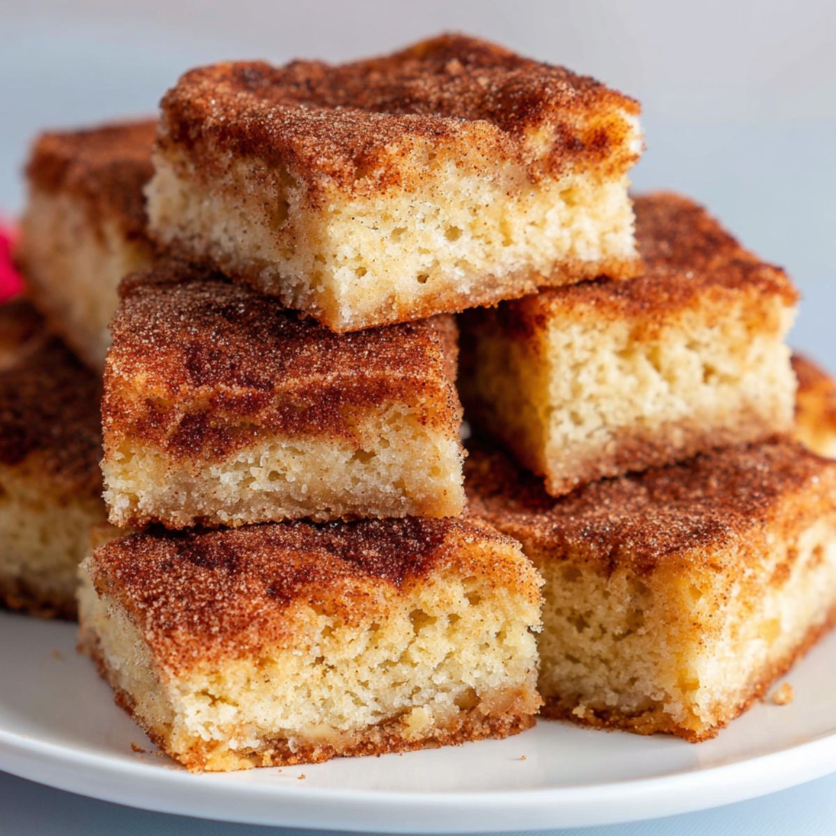 Homemade cinnamon sugar blondies cut into imperfect squares on a white kitchen counter
