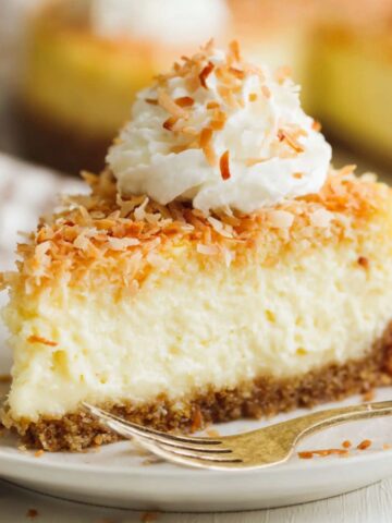 Homemade coconut cheesecake with toasted coconut topping on a white kitchen counter
