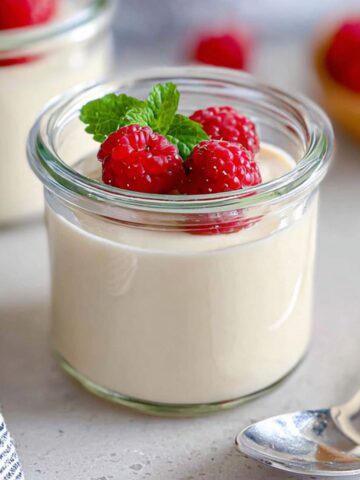 Homemade coconut panna cotta with mango and passion fruit topping on a white kitchen counter,