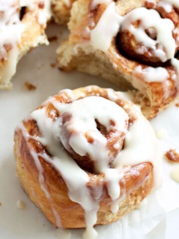Freshly baked banana bread cinnamon rolls in a dish on a white kitchen counter, photographed from above