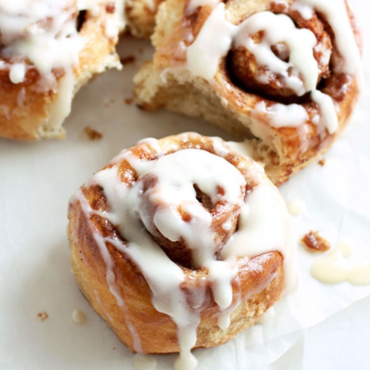 Freshly baked banana bread cinnamon rolls in a dish on a white kitchen counter, photographed from above