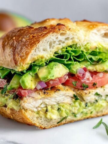 Homemade avocado chicken sandwich on a white kitchen counter