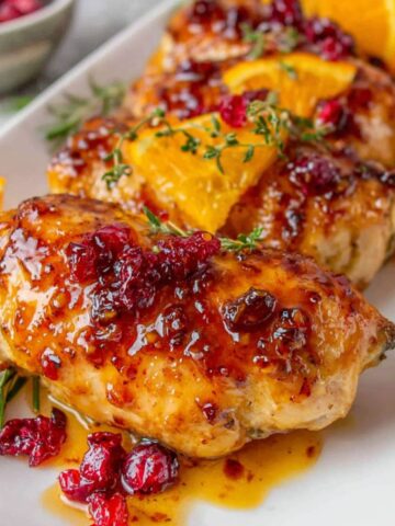 Homemade cranberry orange chicken on a white kitchen counter, top-down view.