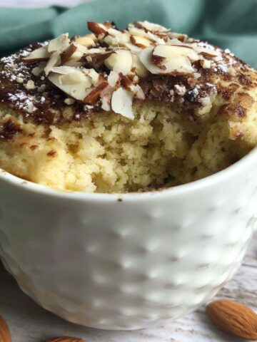Homemade almond flour mug cake on a white kitchen counter