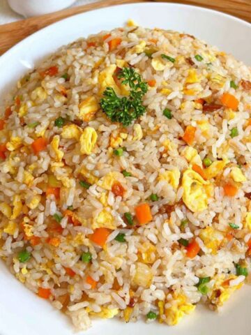 A plate of homemade Chinese egg fried rice on a white kitchen counter