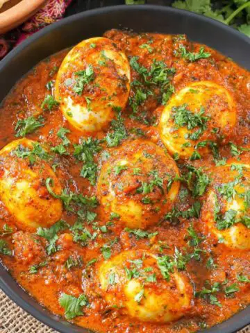 Homemade South Indian egg curry served in a stainless steel bowl on a white kitchen counter.
