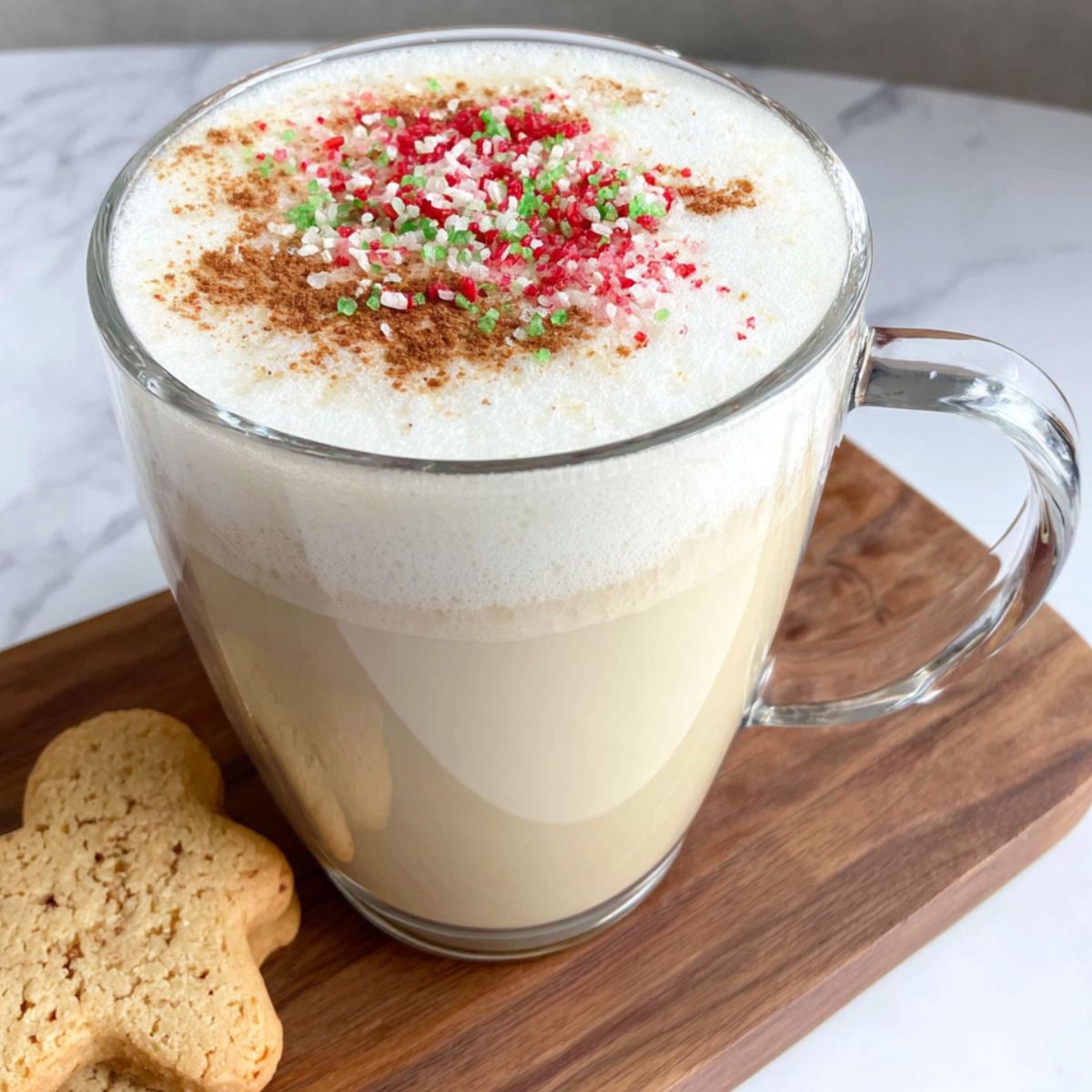 Homemade sugar cookie latte topped with festive sprinkles on a white kitchen counter.