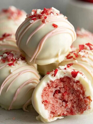 Homemade strawberry truffles on a white kitchen counter photographed from above.